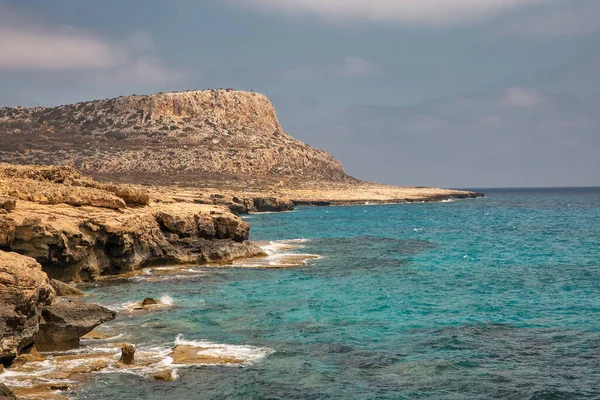 Seascape Cape Greco yarımadası parkı, Kıbrıs. Ulusal parkı, kaya yolları, turkuaz bir gölü ve doğal bir taş köprüsü olan dağlık bir yarımadadır..