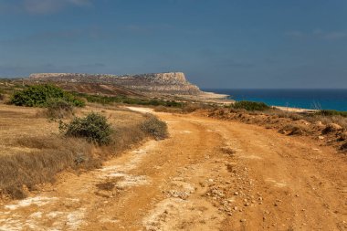Seascape Cape Greco yarımadası parkı, Kıbrıs. Ulusal parkı, kaya yolları, turkuaz bir gölü ve doğal bir taş köprüsü olan dağlık bir yarımadadır..