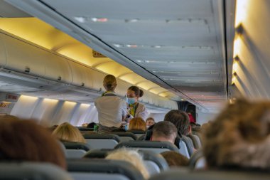 Larnaca, Kıbrıs - 31 Mayıs 2021: Hostes Ukrayna tüzüğü yolcuları ve düşük maliyetli SkyUp Airlines yolcularına ferahlatıcı soğuk ve sıcak içecekler sunuyor. 2021 yılında havayolları 15.962 uçuş gerçekleştirdi.