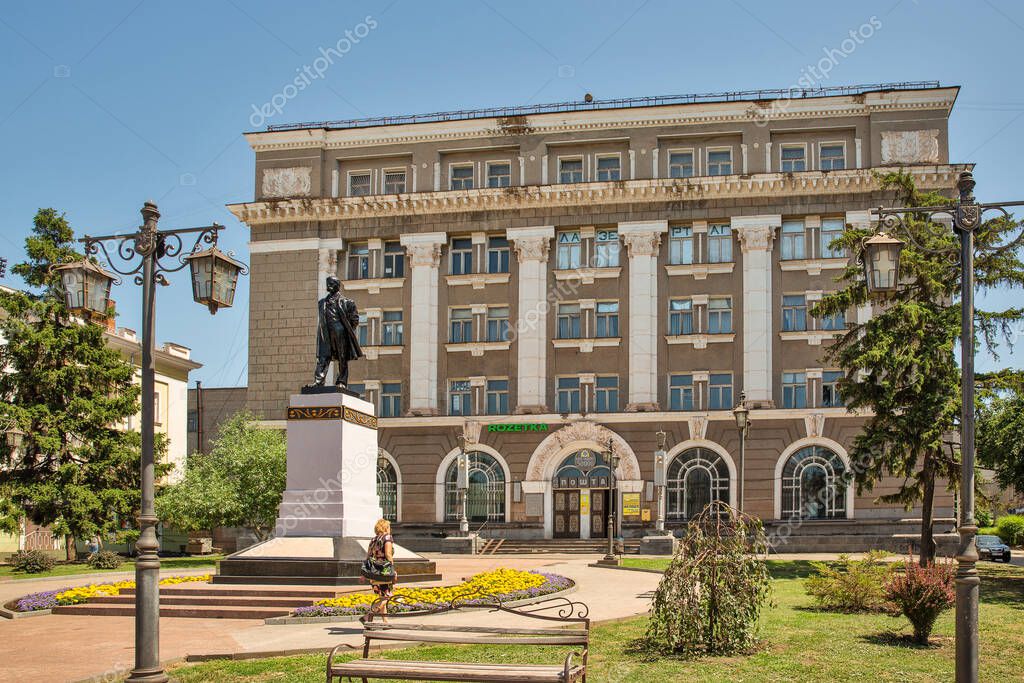 Kryvyi Rih, Ukraine - July 14, 2021: People walk in front of Taras Shevchenko statue and the UkrPoshta central postal department on main street Postal Avenue in downtown.