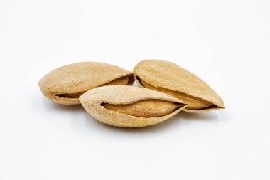 Seçilen birkaç kurutulmuş kabuk bademi beyaz arkaplana yakın plan