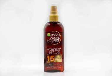 Kyiv, Ukraine - May 16, 2021: Garnier Ambre Solaire sunscreen oil tanning spray flask closeup against white.