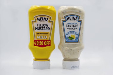 Kyiv, Ukraine - June 02, 2021: Studio shoot of Heinz products in squeezable plastic bottles consisting of Yellow Mustard and Tartare Sauce closeup on white.