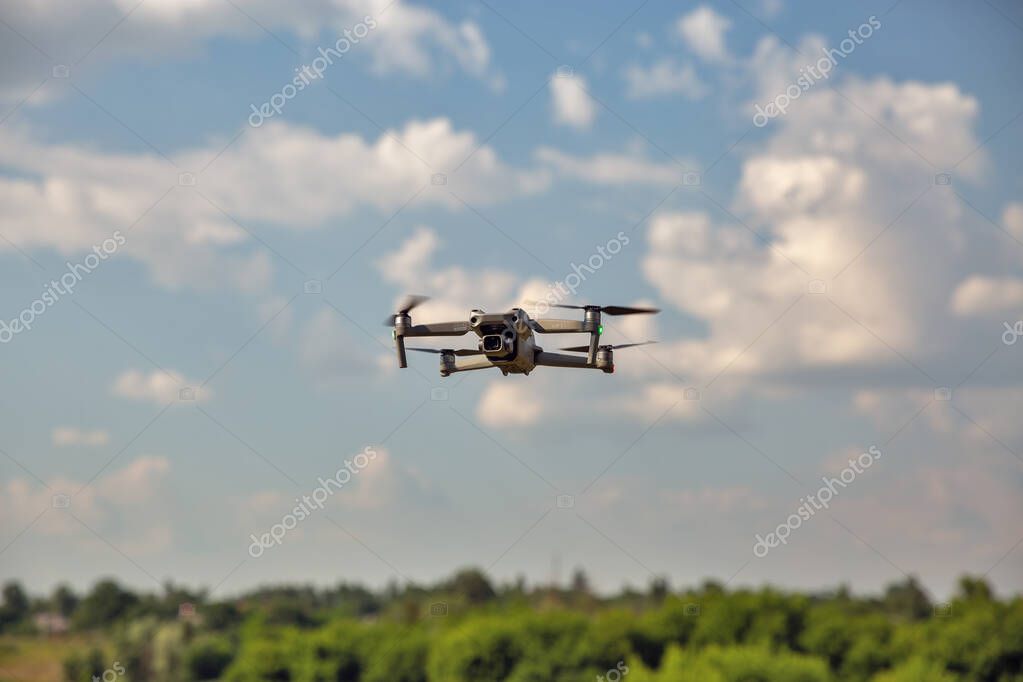 Kyiv, Ukraine - July 11, 2021: Modern drone DJI Mavic Air 2S flying in the sky closeup. DJI is a Chinese technology company manufactures commercial drones for aerial photography and videography.
