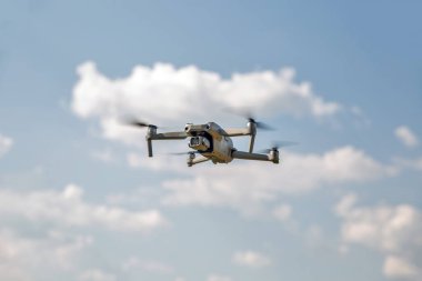 Kyiv, Ukraine - July 11, 2021: Modern drone DJI Mavic Air 2S flying in the sky closeup. DJI is a Chinese technology company manufactures commercial drones for aerial photography and videography.