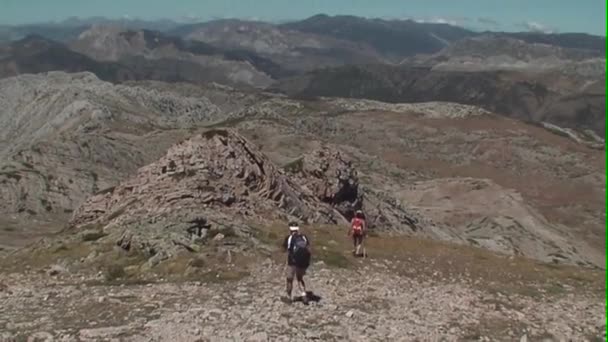 Bergbeklimmers aflopend vanaf de top — Stockvideo