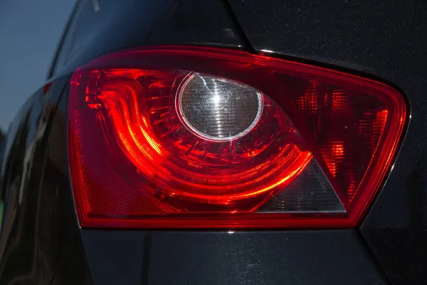 Detail Des Rot Metallisierten Schwarzen Autoscheinwerfers Augenform Mit Sonnenreflexion Der — Stockfoto