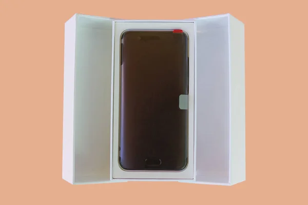 智能手机移动电话 后面有保护塑料 在其最初的打开的盒子中 在色彩背景上隔离 — 图库照片