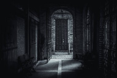 Korkunç geçit, eski tuğla kemer ve paslı demir kapı, kırık körlüğe doğru gidiyor.