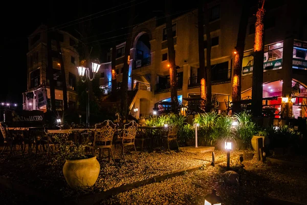 VILLA GESELL, ARGENTINA, NOVEMBER 14, 2019: Night scene of an elegant outdoor bar illuminated by small lamps among the trees and plants — Stock Photo, Image