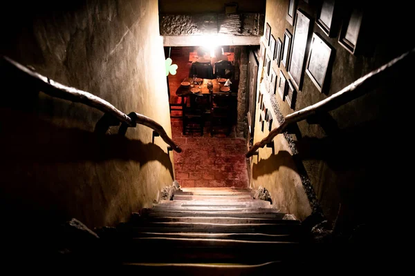 VILLA GESELL, ARGENTINA, NOVEMBER 14, 2019: Dramatic point of view of scary stairs from upside into darkness of interior of old pub — Stock Photo, Image