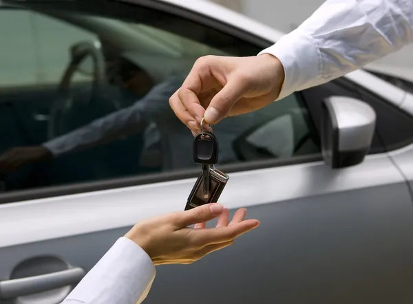 Femme recevant la clé de voiture de l'homme — Photo