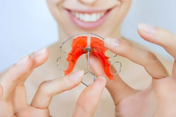 Menina sorridente com retentor nos dentes — Fotografia de Stock