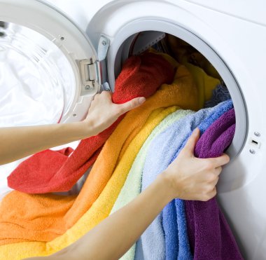 woman taking color clothes from washing machine clipart