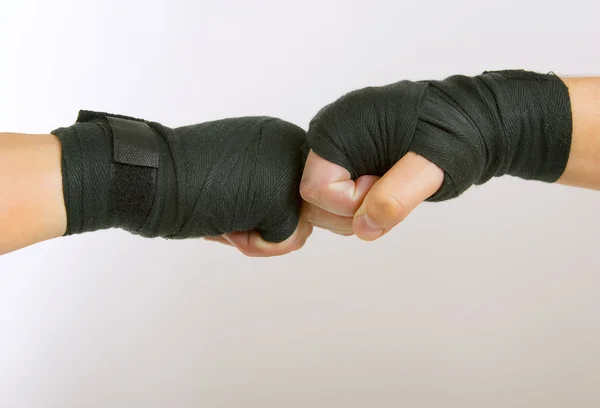 Two hands in a black boxing bandage arm wrestling, clasped — Stock Photo, Image