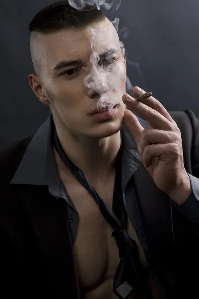 Ένα πορτρέτο ενός νεαρού άνδρα που καπνίζει ένα τσιγάρο — Φωτογραφία Αρχείου