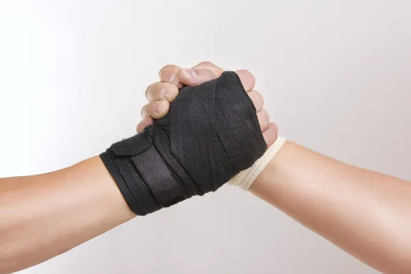 Two hands clasped arm wrestling, the struggle of black and white — Stock Photo, Image