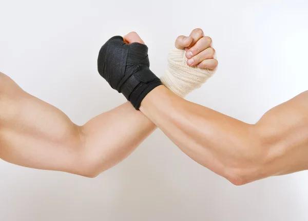 Two hands clasped arm wrestling, the struggle of black and white — Stock Photo, Image