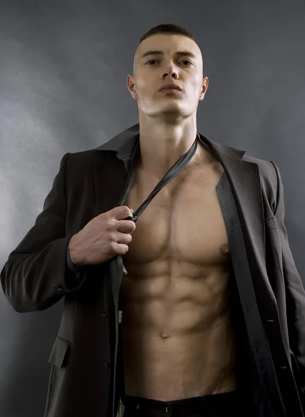 Young sexy man with athletic body posing on black background. — Stock Photo, Image