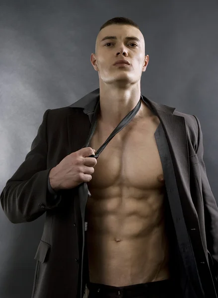 Junger sexy Mann mit athletischem Körper posiert auf schwarzem Hintergrund. lizenzfreie Stockfotos