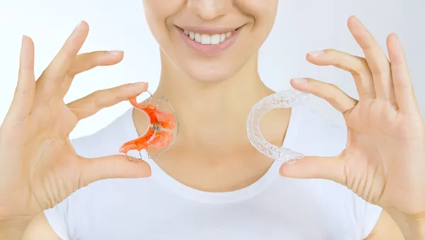 Hands holding retainer for teeth and tooth tray — Stock Photo, Image