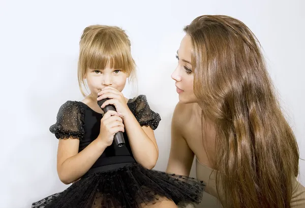 Little girl singing in microphone - mother and girl with a micro — Stock Photo, Image