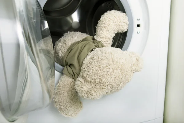 Washing soft toys: soft toy falling out of a washing machine — Stock Photo, Image