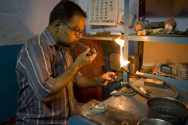 VARANASI, INDIA - MAY 15: Unidentified man working jeweler.