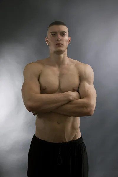 Young sexy man with athletic body on black background. — Zdjęcie stockowe