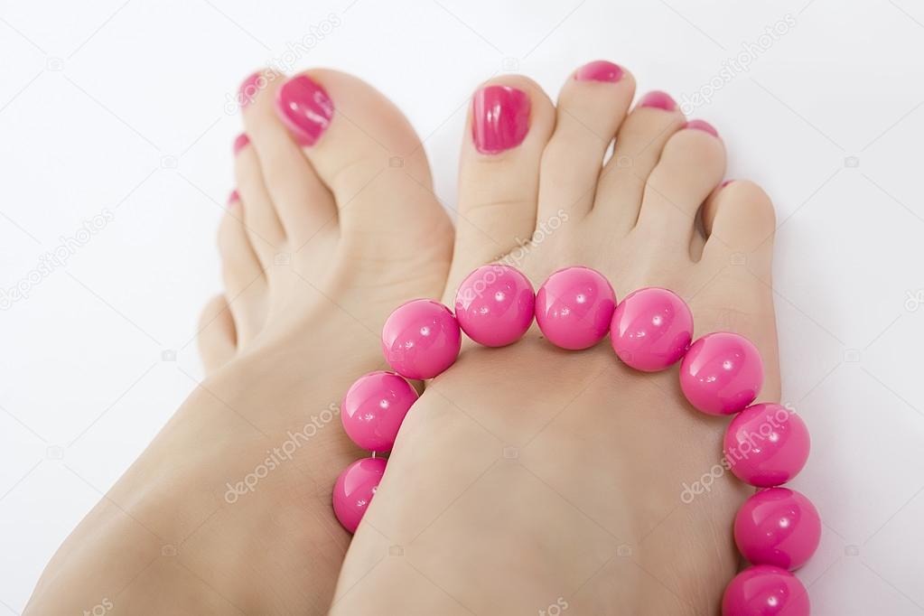 female foot with pink pedicure and accessory