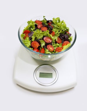 diyet. ağırlık ölçekli bir kase sebze salatası