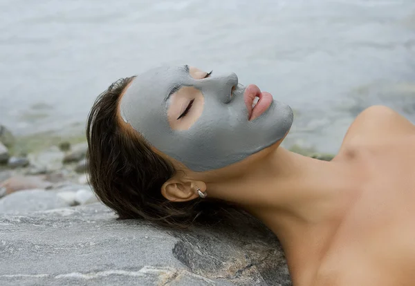 Vrouw met blauwe klei gezichts masker in schoonheid Wellness — Stockfoto