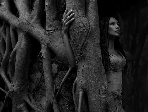 Beautiful young Woman near Banyan Tree in the rainforest in Indi