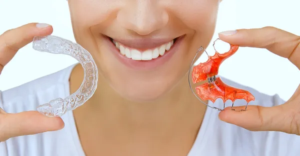 Mãos segurando retentor para dentes e bandeja de dentes — Fotografia de Stock