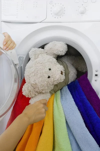 Mulher tomando brinquedo da máquina de lavar roupa — Fotografia de Stock