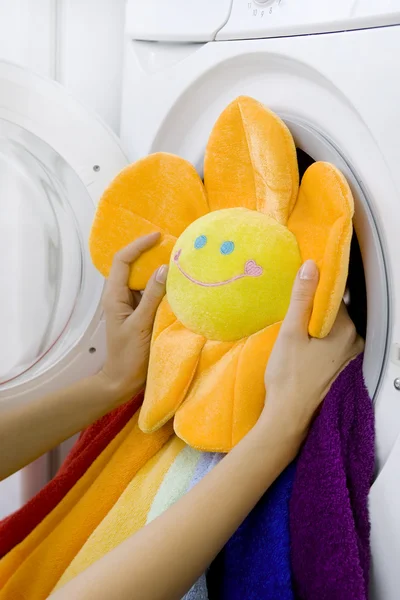 Woman taking fluffy toy from washing machine — Stock Photo, Image