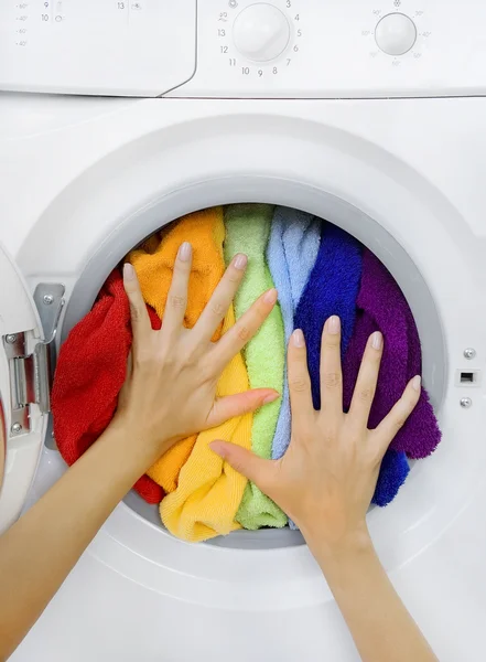 Mulher carregando roupa colorida na máquina de lavar roupa — Fotografia de Stock