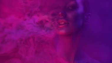Kadın sanat portre. Güzel seksi genç kadınla gece kulübünde göz alıcı mistik makyaj. Kız kulübü Cadılar Bayramı partisinde sigara. Mavi mistik ışık. Gece hayatı ve Bodyart