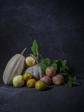 Balkabağı, limon, elma ve armut, koyu arka planda tropikal meyveler