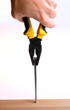 bir çivi pense ile çekerek