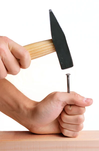 Hammering a nail into wooden plank. — Stock Photo, Image