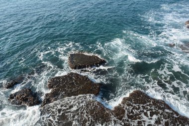 Deniz Dalgaları Beyaz Köpükle Kayalıklara Çarpıyor. Akko (Acre) İsrail yakınlarındaki kayanın üzerinde köpüklü köpüklü deniz suyu kıvrılıyor