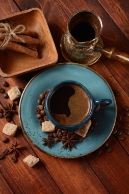 Kahve fincanı, demerara esmer şeker küpleri, eski mutfak masasında kahve ve fasulye.