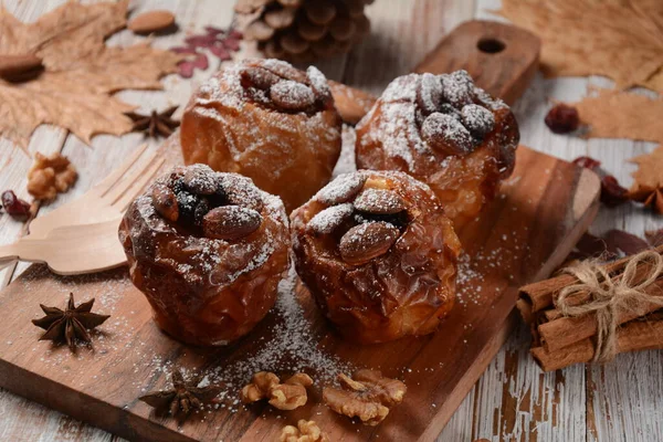 Baked apples with nuts and raisins. Homemade baked apples in the oven, with sugar powder close-up. Holiday dessert