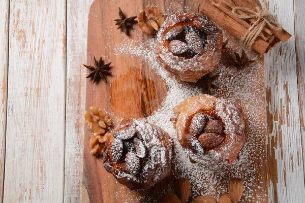 Baked apples with nuts and raisins. Homemade baked apples in the oven, with sugar powder close-up. Holiday dessert