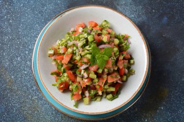 Domatesli Shirazi Salatası, salatalık, kırmızı soğan, maydanoz ve beyaz kasede taze limon suyu. Persian Shirazi sebze salatası yakın plan. Popüler İsrail yemekleri