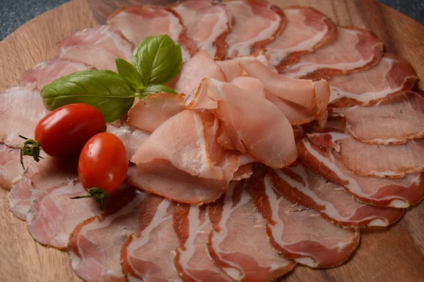 Italian cured pork shoulder. Antipasto Platter coppa stagionata and cherry tomatoes.  Traditional sliced sausage with spices