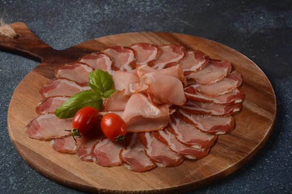 Italian cured pork shoulder. Antipasto Platter coppa stagionata and cherry tomatoes.  Traditional sliced sausage with spices