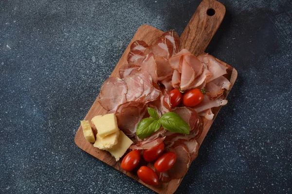 Italian cured pork shoulder. Antipasto Platter coppa stagionata and cherry tomatoes.  Traditional sliced sausage with spices