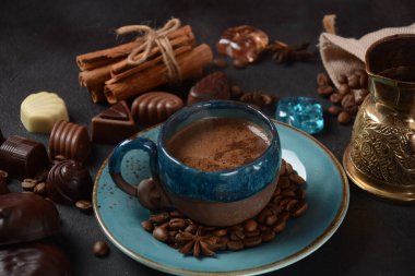 Kahve fincanı, fasulye, eski mutfak masasındaki çikolatalar koyu, beyaz ve sütlü çikolatalı tatlılar, zefir (zephyr). Baharatlar, tarçın.